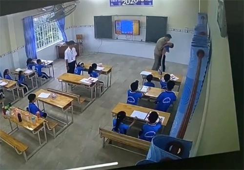 Thầy giáo túm cổ một học sinh, nhấc bổng lên để đưa ra khỏi lớp. Ảnh cắt từ clip.